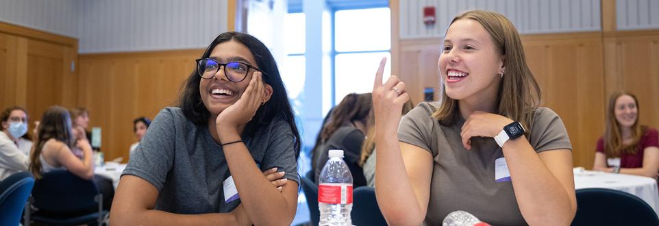 Two girls sitting at table gesturing