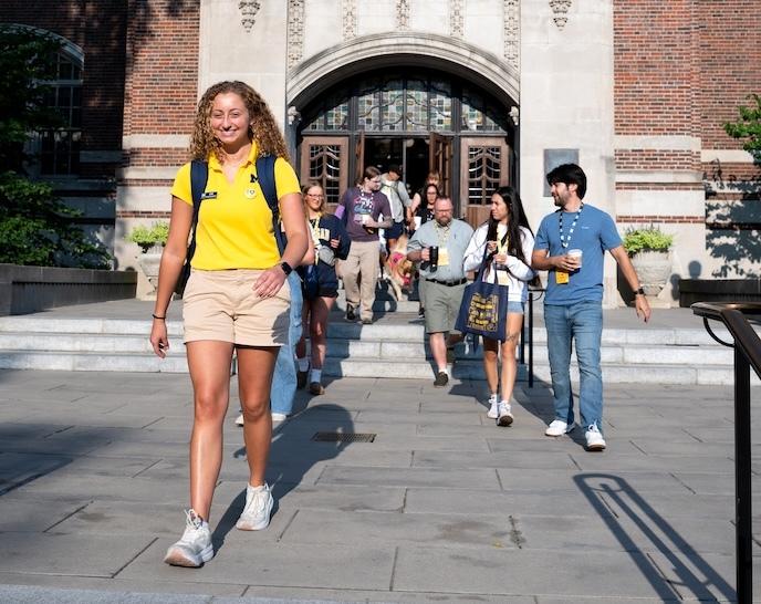 An Orientation Leader with a group of students and parents outside the Michigan Union.