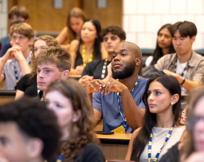A large group of students listen to a presenation at Orientation