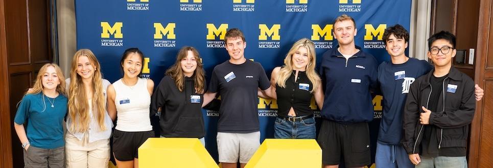 Group of mentors standing in front of block M background.